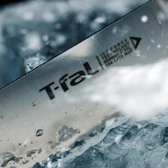 Close-up of T-fal knife blade with water splashes and ice fragments.
