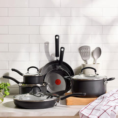 hard anodized ceramic cookware set with glass lids and cooking utensils on a kitchen counter.