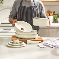 Man holds beige non-stick cookware with detachable handle on kitchen counter