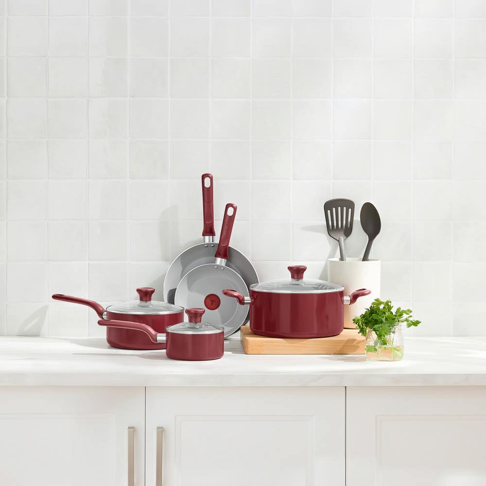 T-fal red cookware set with two frypans, stockpot, saucepan and sauté pan on countertop