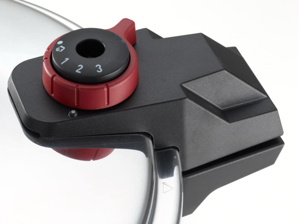 Black and red pressure cooker lid handle with numbered dial to adjust pressure levels between 1 and 3 and a steam release function.