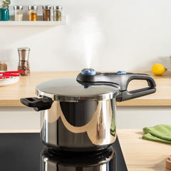 Pressure cooker releasing steam in bright kitchen with on wooden countertop