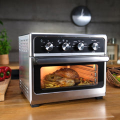 The Easy Fry Oven cooking a chicken and some fries on a kitchen countrtop