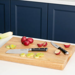 Two T-fal knives on cutting board with potatoes and leeks.