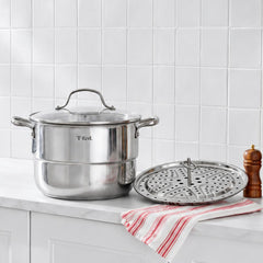 T-fal stainless steel steamer pot with glass lid and perforated insert on kitchen counter