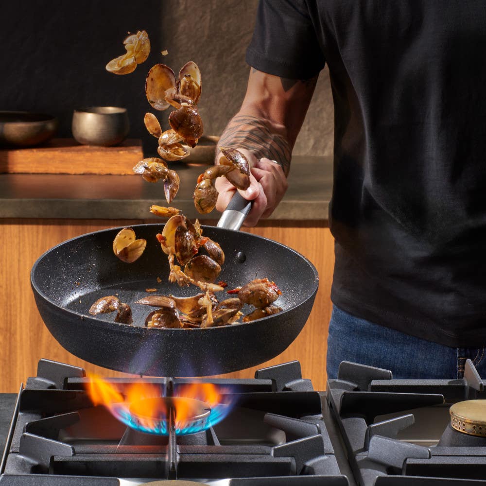 Tossing potatoes in a Stone Force Frying Pan on the stove.