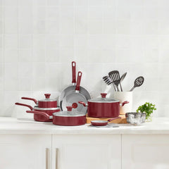 Red cookware set with frypans, stockpot, saucepan and steamer on kitchen countertop