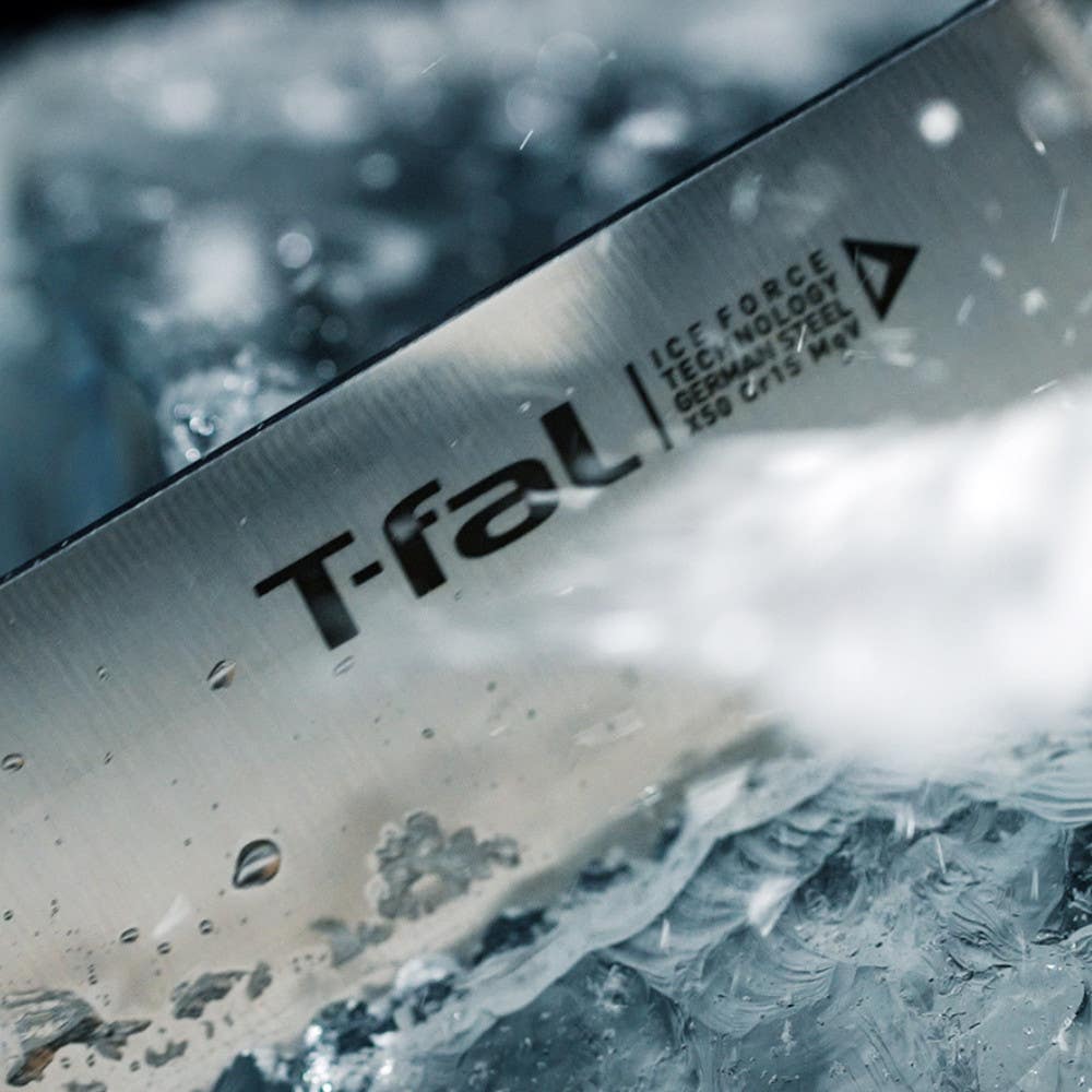 Close-up of T-fal knife blade with water splashes and ice fragments.