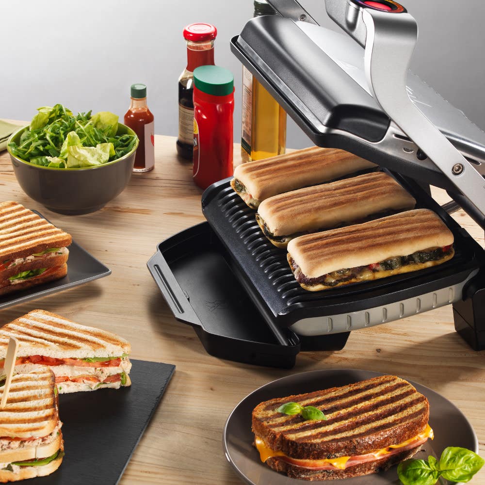 Open OptiGrill cooking sandwiches in countrtop alongside condiments