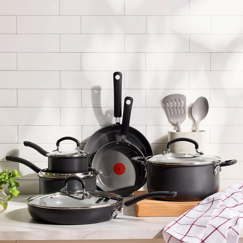 hard anodized ceramic cookware set with glass lids and cooking utensils on a kitchen counter.