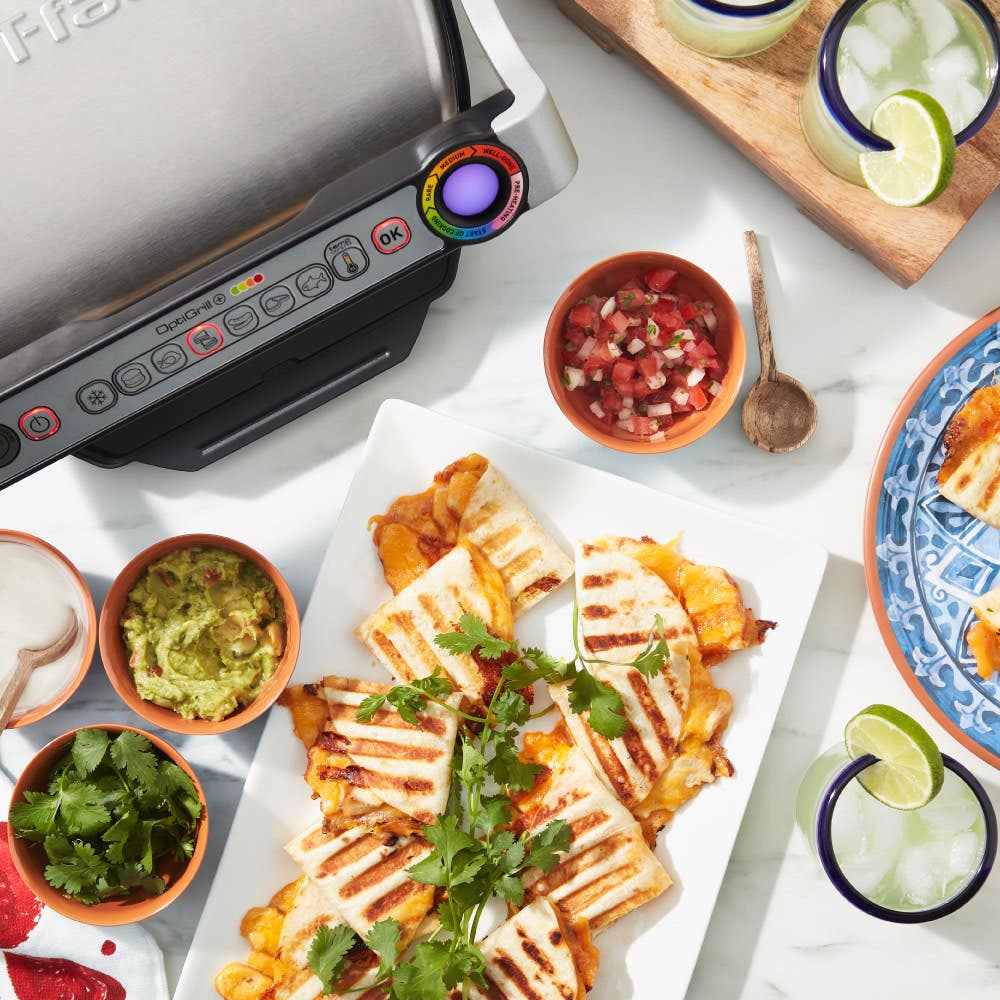 Freshly grilled quesadillas around T-fal OptiGrill; served with bowls of guacamole, salsa, and sliced vegetables