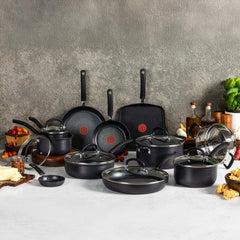 Black nonstick cookware set with pots, frying pans, griddle, glass lids on marble counter