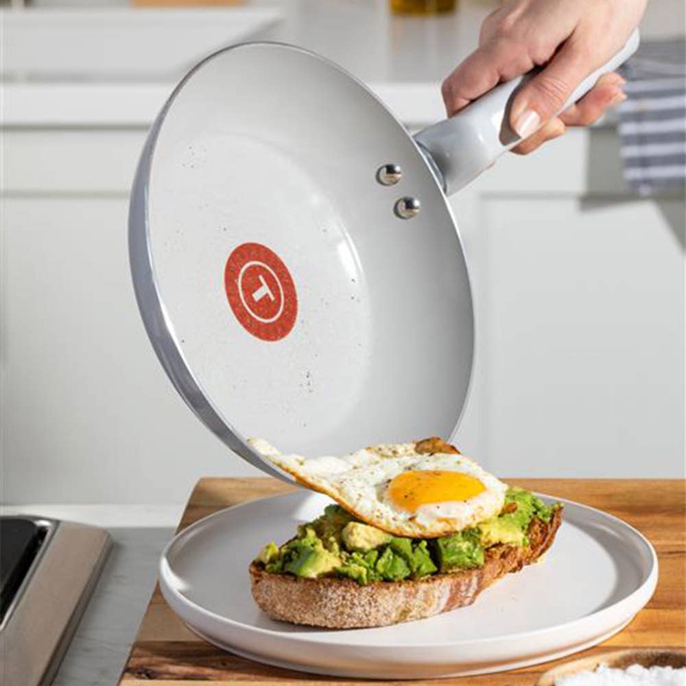 Gray ceramic frypan serving a fried egg o avocado toast; labeled Made without PFOA & PTFE
