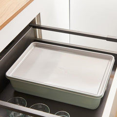 Rectangular baking pan nested in a roasting pan stored in open kitchen drawer.
